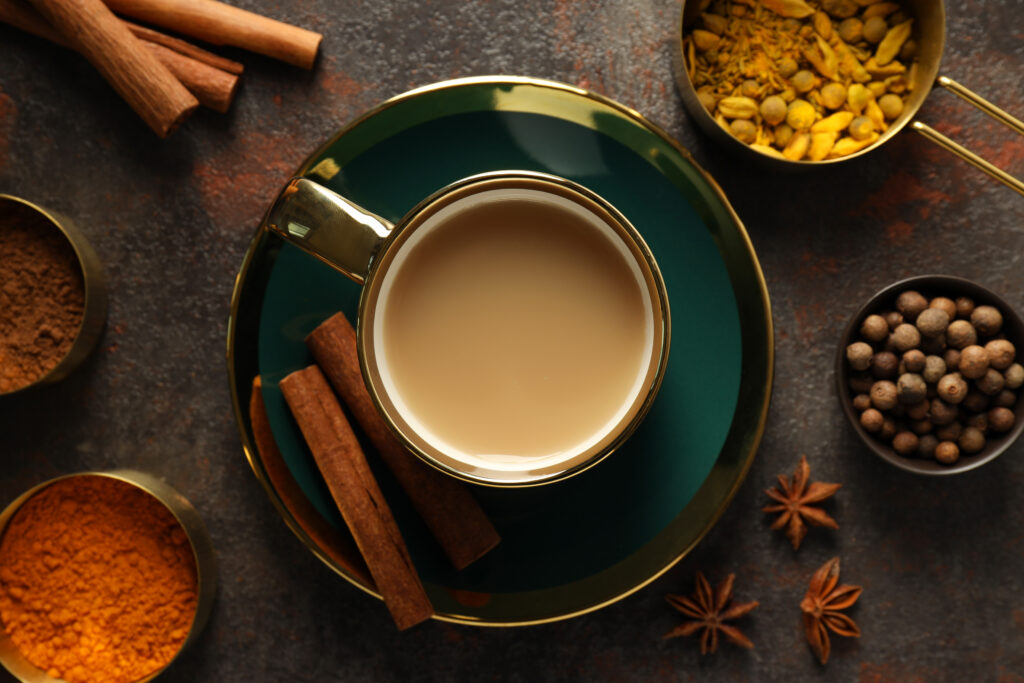 Masala tea and spices on dark gray background, top view