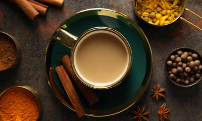 Masala tea and spices on dark gray background, top view