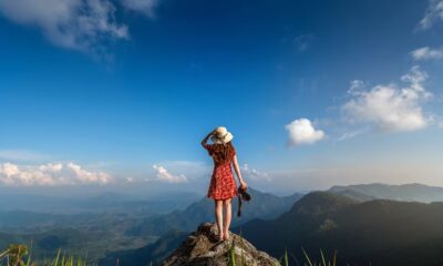 woman-hand-holding-camera-standing-top-rock-nature-travel-concept_335224-887